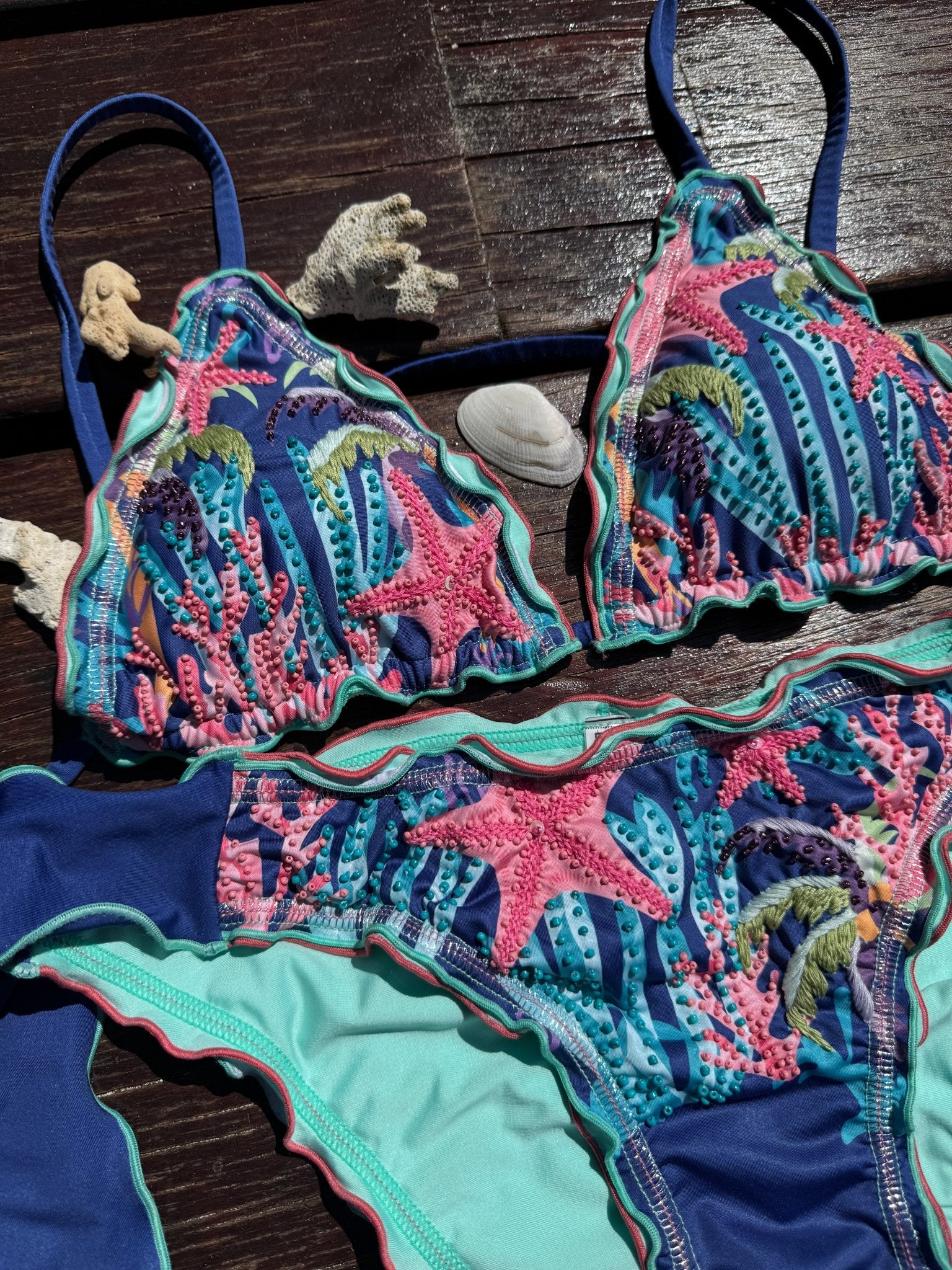 CALASWIM Bahia hand beaded triangle bikini top on tropical wood with starfish and coral, luxury artisan swimwear